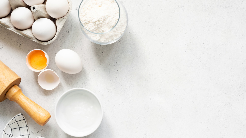 eggs with a rolling pin and cup of flour