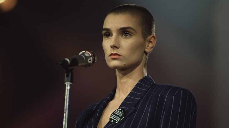 Sinead O'Connor standing behind a microphone