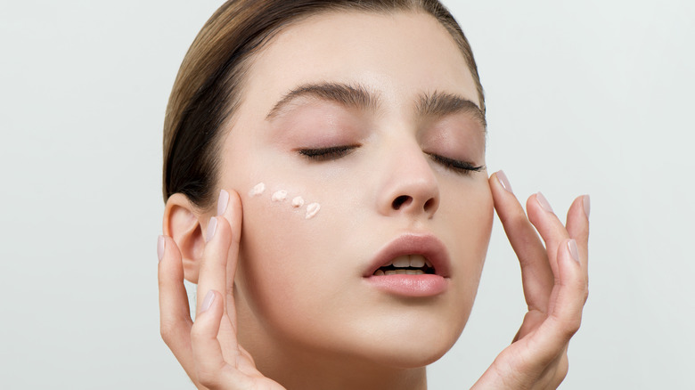 Woman applying concealer