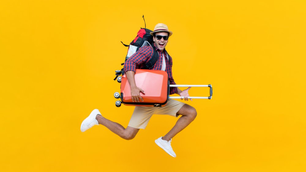 man with luggage jumping