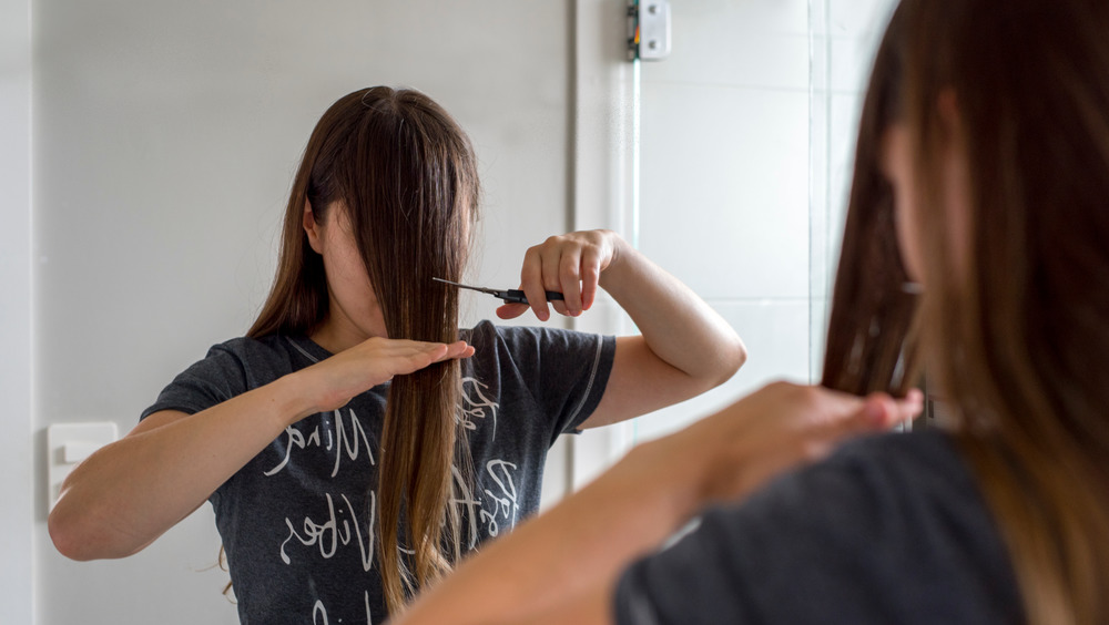 Woman cutting bangs herself