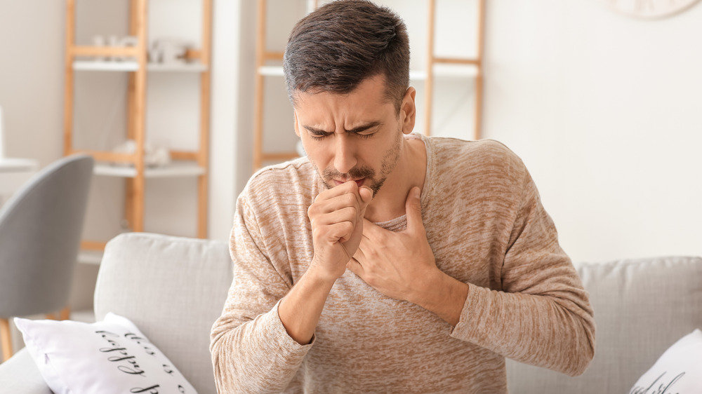 A man coughing