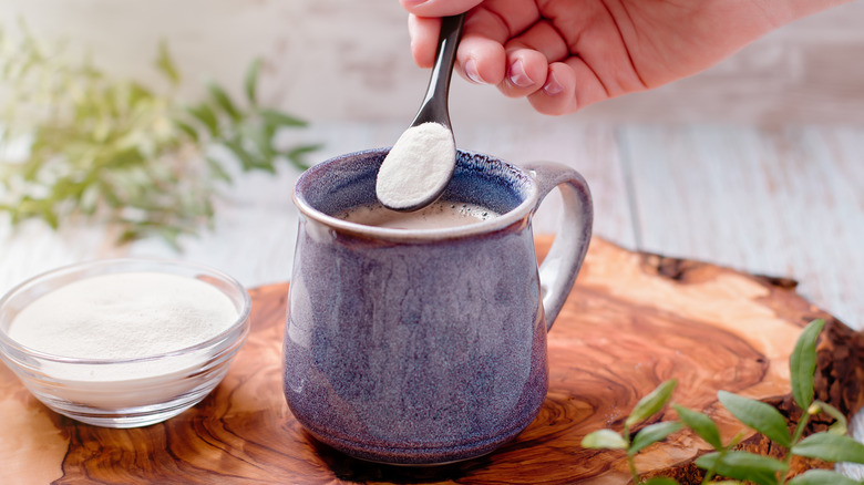 Pouring collagen powder into coffee