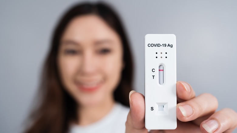 woman holding negative COVID test