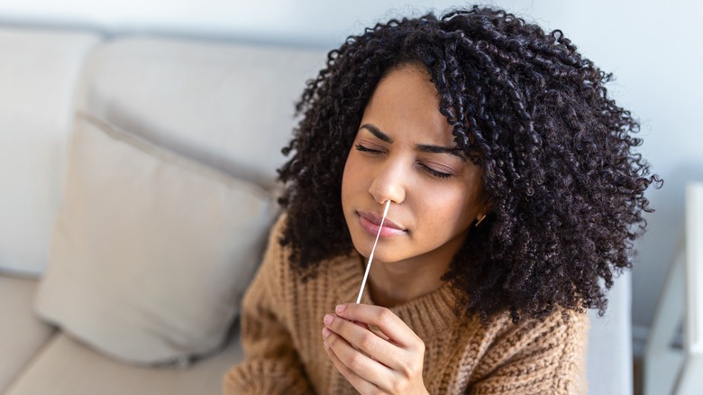 woman swabbing nose COVID test