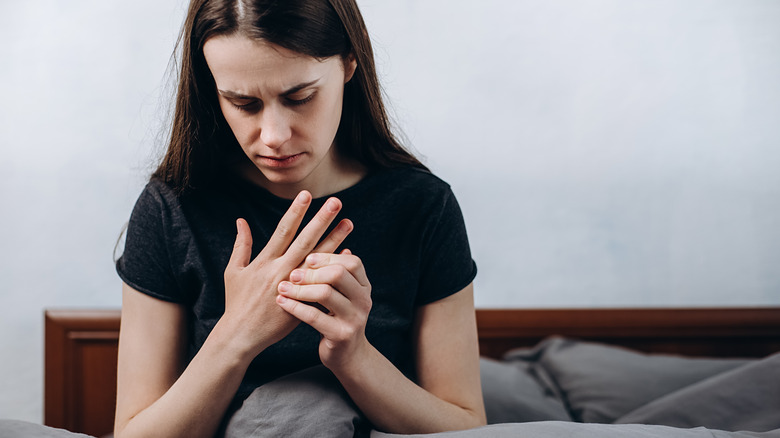 Woman in pain holding hand