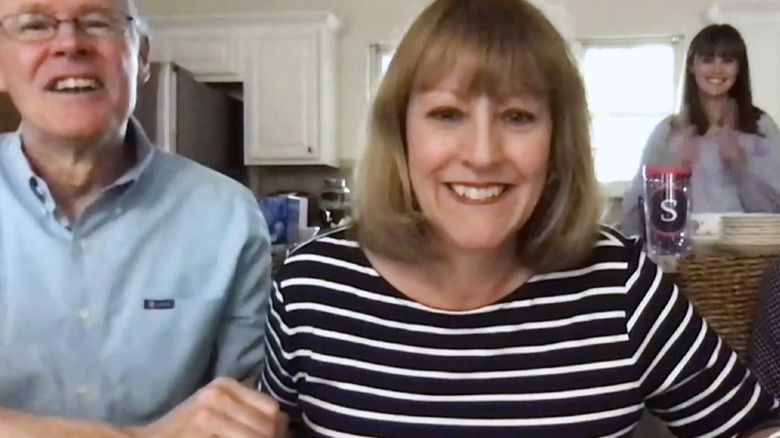 Man and two women smiling at camera during video call