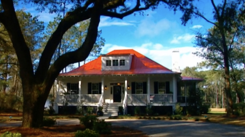 Big house with red roof surrounded by trees