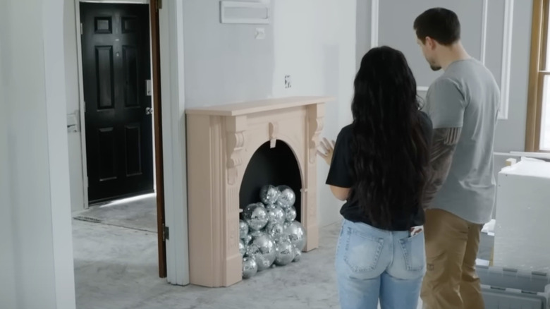 Chelsea and Cole standing in front of disco fireplace