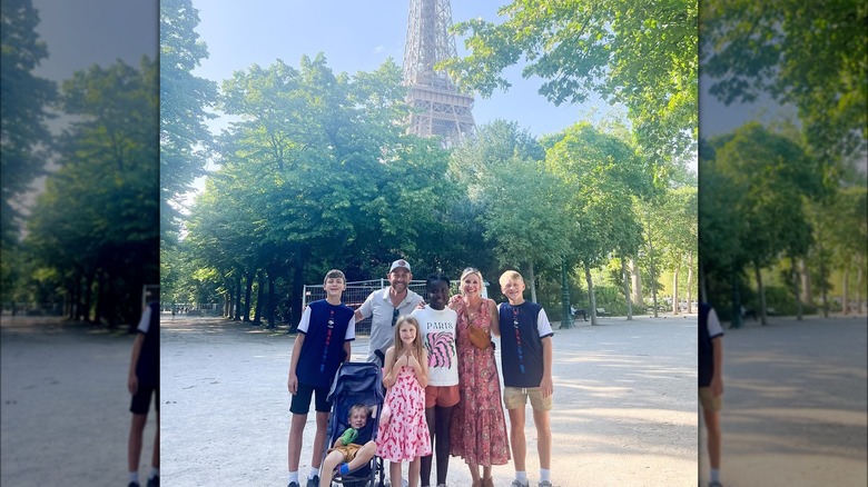 Dave and Jeny Marrs and their five kids smiling in front of the Eiffel Tower