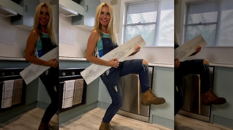 Cherie Barber in kitchen holding wood panel