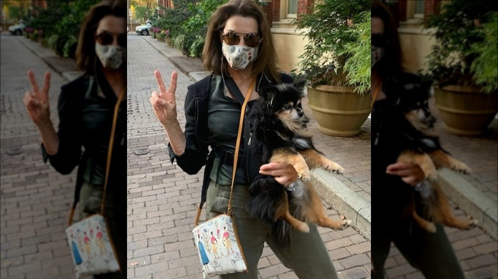 Hilary Farr flashing the peace sign with her dog