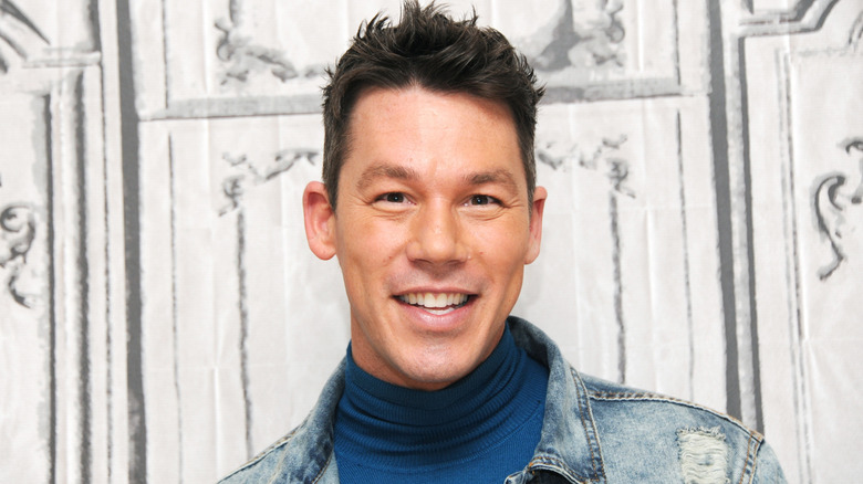 David Bromstad smiling in front of a white background