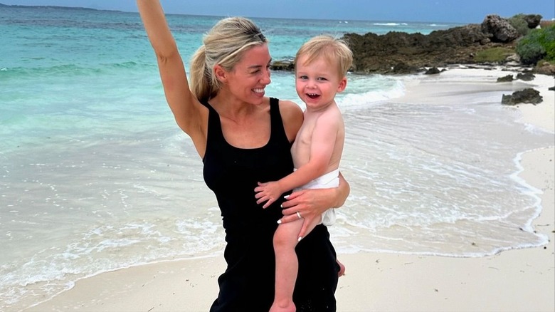 Heather Rae Young smiling and holding her son Tristan El Moussa