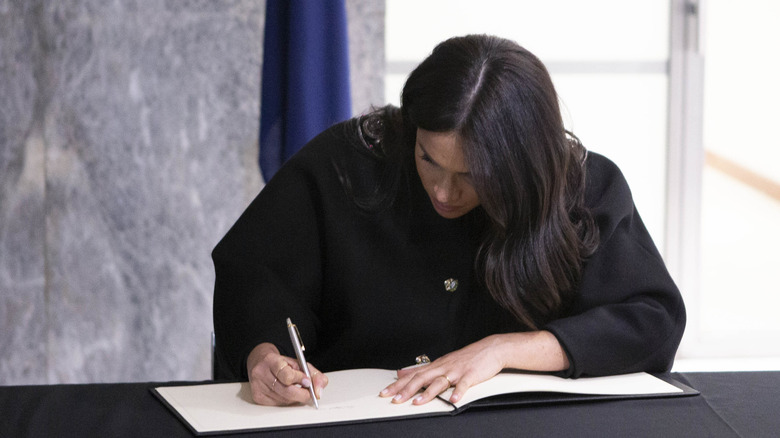 Meghan Markle signing a guestbook