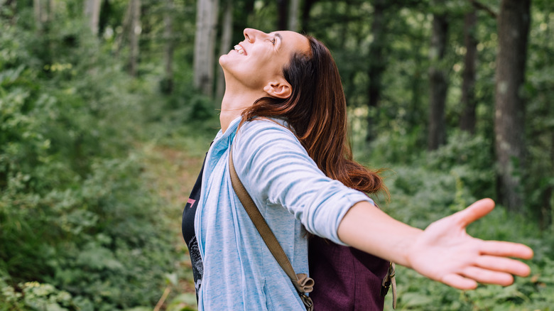 woman happily forest bathing