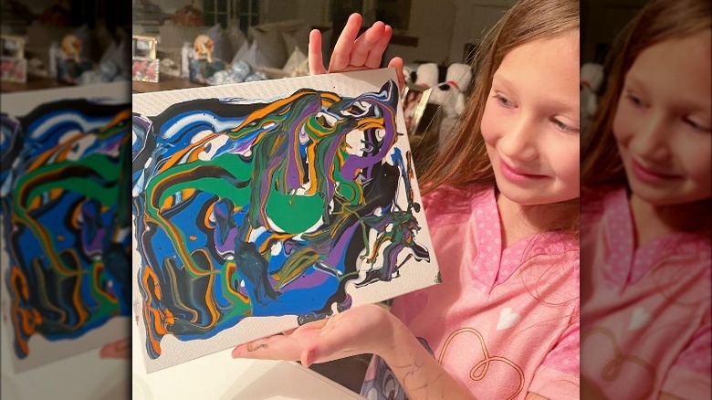 Hilaria Baldwin's daughter with a piece of artwork