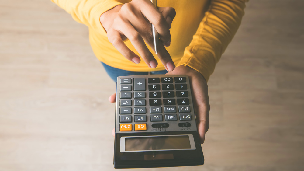 Woman's hands holding calculator and pen