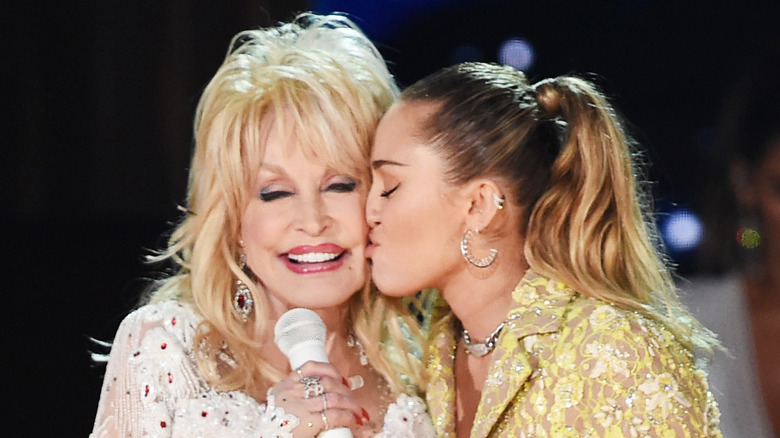 Miley Cyrus kissing Dolly Parton on the cheek