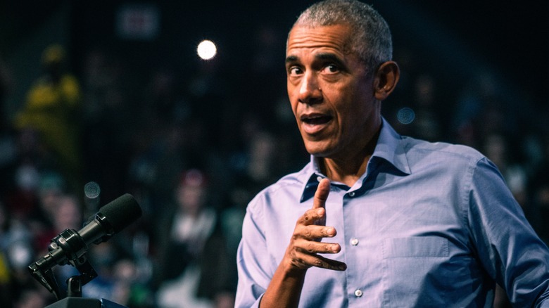 Barack Obama speaking at podium, gesturing with hand