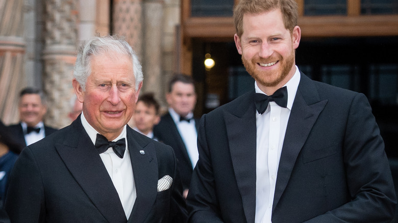 Prince Harry and King Charles III smiling at the camera