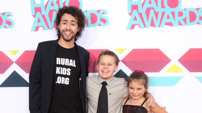 Ramy Youssef standing on awards red carpet with kids