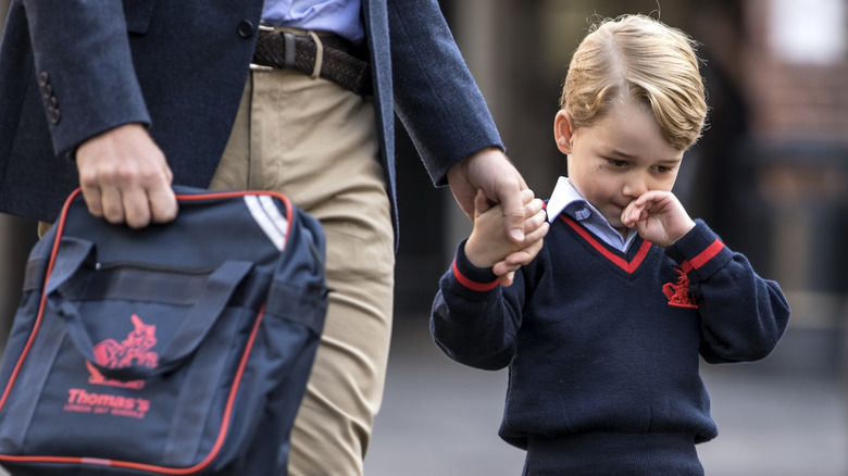 Prince George holding Prince William's hand 