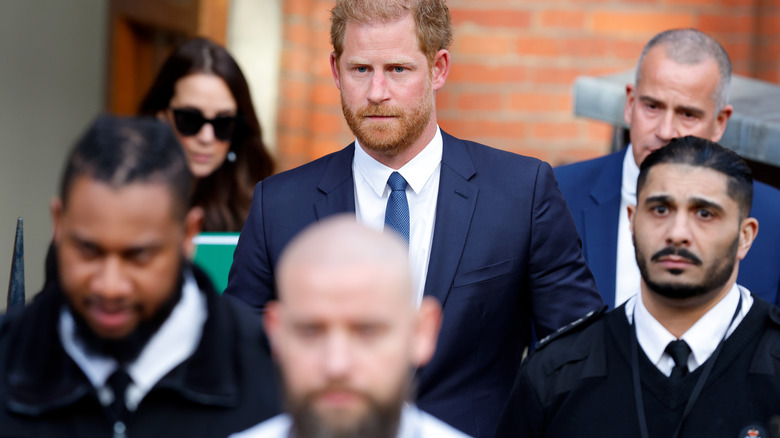 Prince Harry leaving court with guards