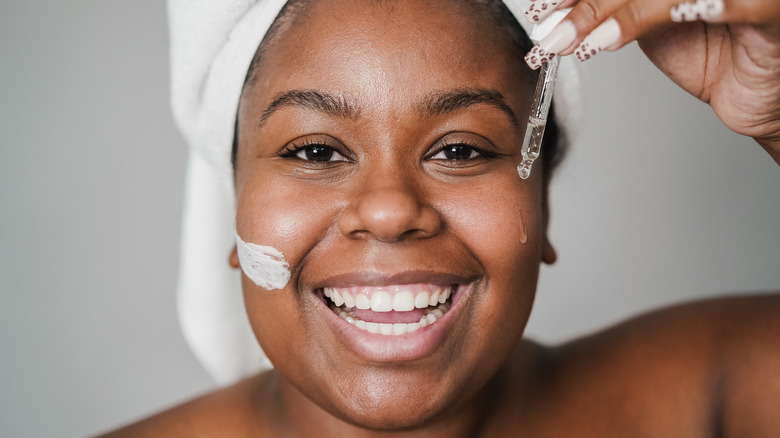 Woman smiling and wearing serum