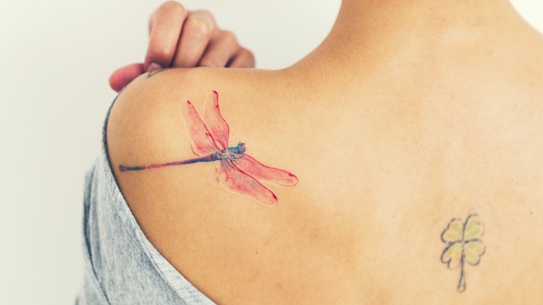 Woman showing tattoo on shoulder blade