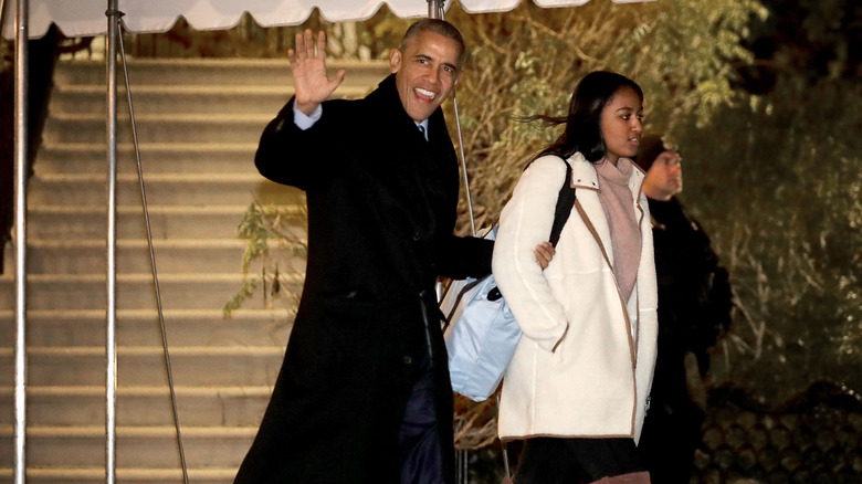 Barack Obama waving as he walks with his daughter Sasha