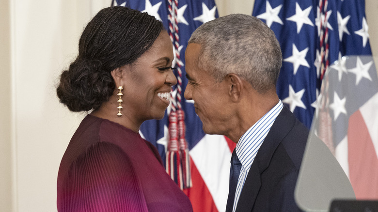 Barack and Michelle Obama embracing and smiling 