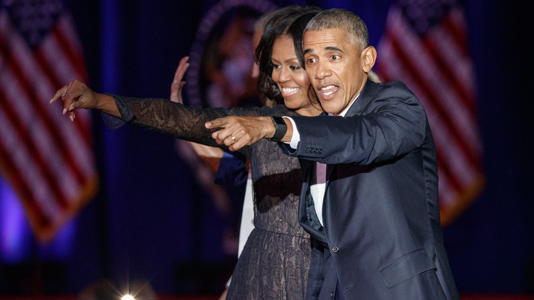 Michelle and Barack Obama waving on stage