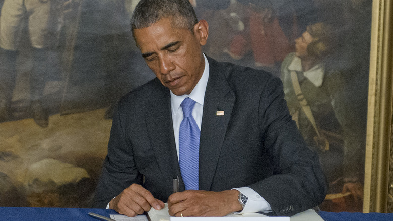 Barack Obama focused on signing a book 