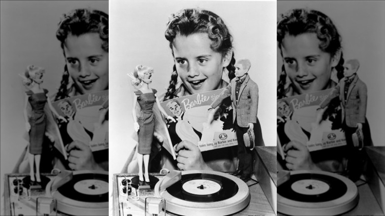 Young girl plays with Barbie and Ken in 1961