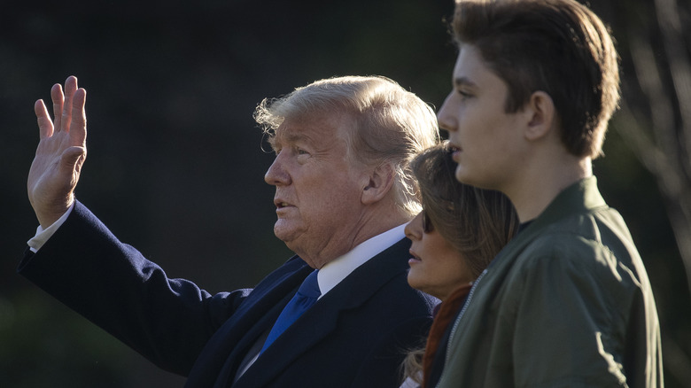 Barron Trump towering over his parents