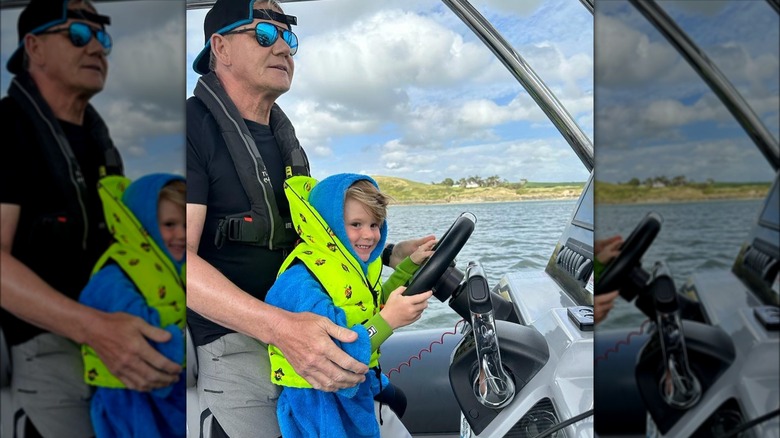 Gordon Ramsay driving a boat with his young son Oscar