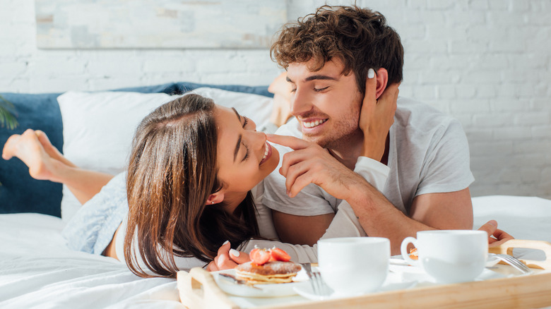 A couple eating breakfast in bed