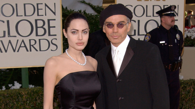 Angelina Jolie and Billy Bob Thornton in formal wear with Golden Globe signs and a police officer behind them