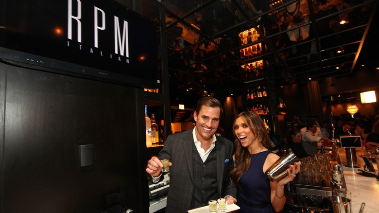 Bill and Giuliana Rancic holding a tray of shots