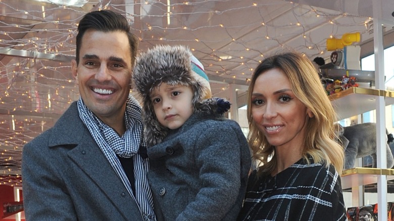 Bill Rancic holding Duke while Giuliana watches