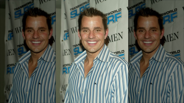 A young Bill Rancic smiling in a striped shirt