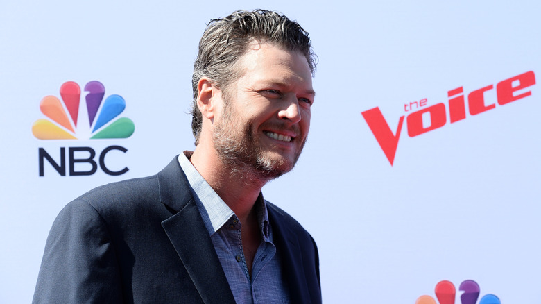 Blake Shelton smiling, promoting The Voice