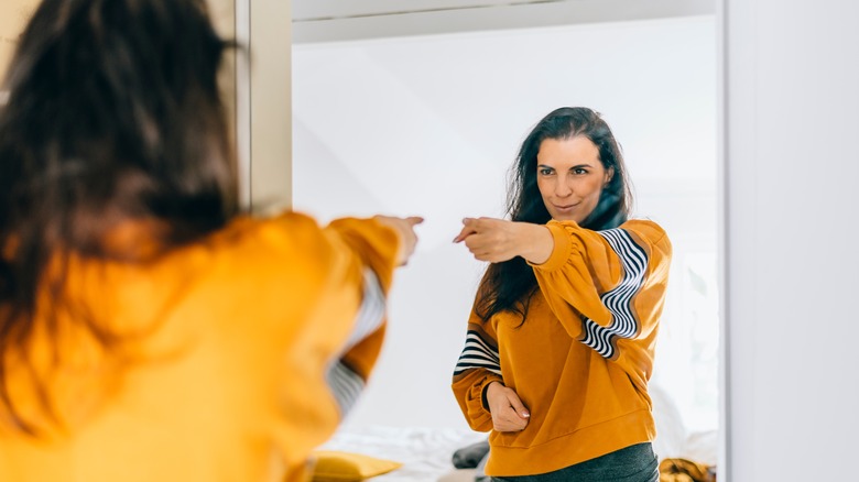 Woman pointing at mirror 
