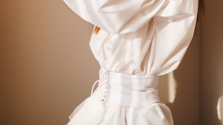 Woman wearing an all white outfits with a corset