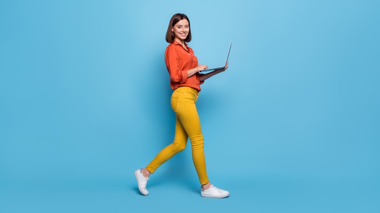 Girl walking and holding laptop