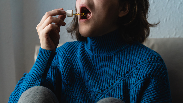 woman taking CBD oil