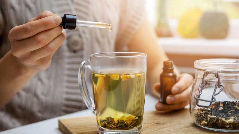 Woman adding CBD to tea