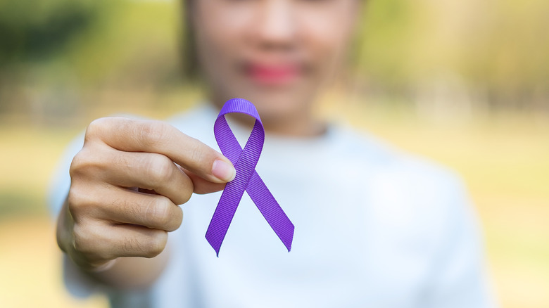 Woman holds purple ribbon representing epilepsy awareness