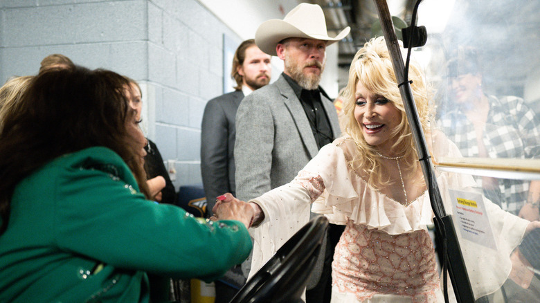 Loretta Lynn holding hands with Dolly Parton at CMAs